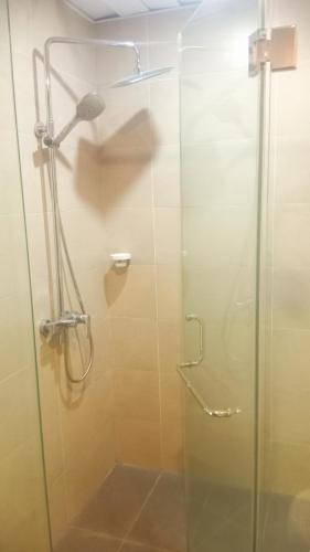 a shower stall with a glass shower door at Water Park Suites in Nugegoda