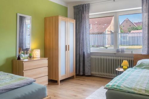 a bedroom with a bed and a dresser and a window at Ferienwohnung Dorfliebe in Gerolfingen