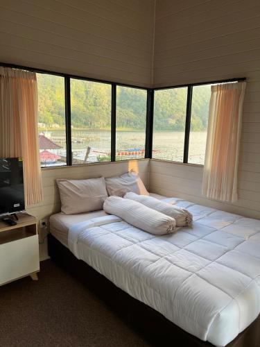 a large bed in a room with windows at Beji Bedugul Glamping in Bedugul