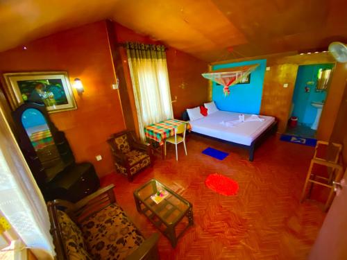 an overhead view of a bedroom with a bed and chairs at La Casa Safari Cottages & TREE HOUSE in Udawalawe