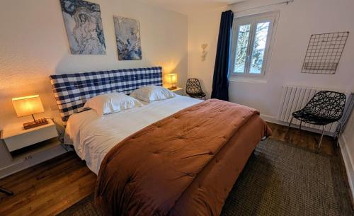 a bedroom with a large bed with two chairs and a window at Villetelle in Cheissoux