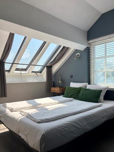 a large bed in a room with a large window at Hotel Oostereiland in Hoorn