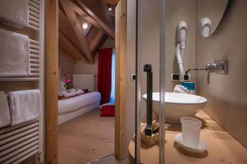a bathroom with a sink and a bed in a room at Hotel Cristallo in Livigno