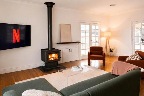 a living room with a couch and a stove at Yarra Palms in Yarrawonga
