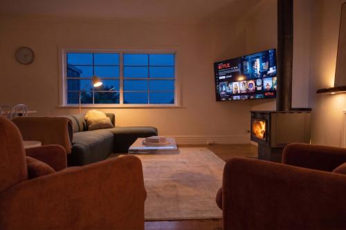 a living room with a couch and a fireplace and a tv at Yarra Palms in Yarrawonga