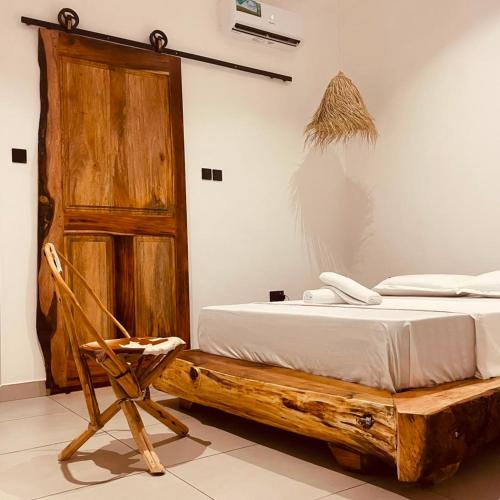 a bedroom with a bed and a wooden door at Maison Studio indépendante in Nungwi