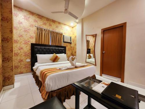 a hotel room with a bed and a desk in it at Hotel Housez 43 in Kolkata