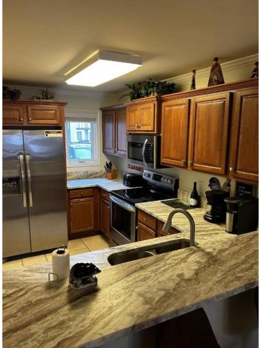 a kitchen with wooden cabinets and a stainless steel refrigerator at River & Vine in Helen