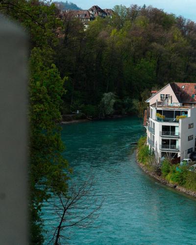 a view of a river with buildings and trees at One Suite Hotel - Zollhaus in Bern