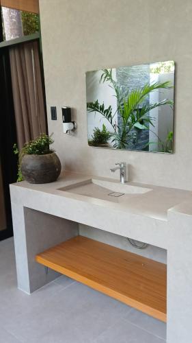 a bathroom with a sink and a mirror at Taluna Villas in Panglao Island