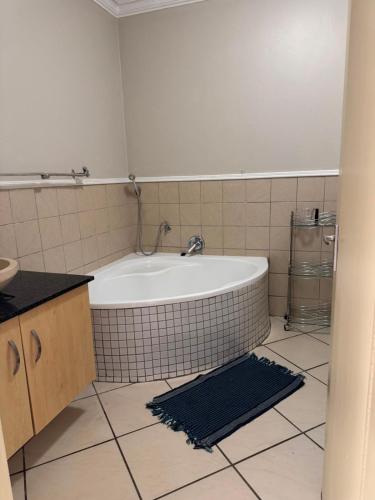 a bathroom with a tub and a tiled floor at Premium Getaway @ la Bella Costa in Pretoria