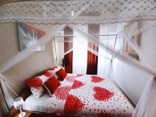 a bedroom with a red and white bed with a window at Appartement VIP centre ville in Toamasina