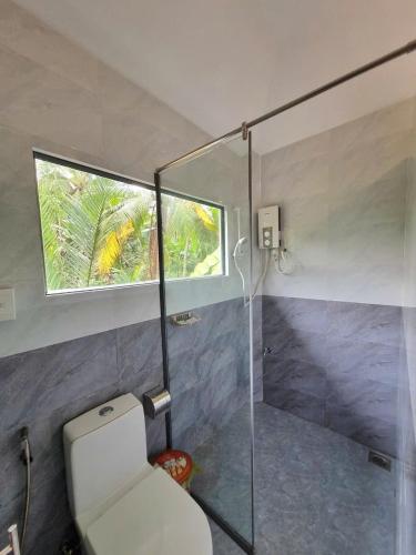 a bathroom with a toilet and a window at Homestay Nam Hàm Luông in Ben Tre