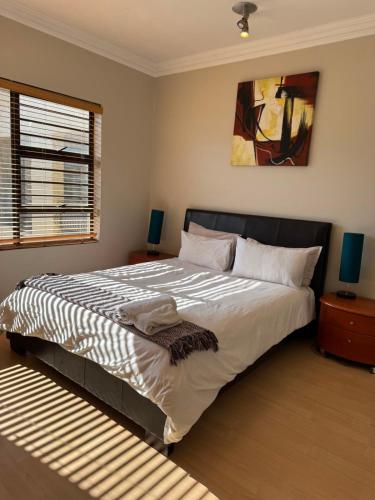 a bedroom with a large bed and a window at Premium Getaway @ la Bella Costa in Pretoria