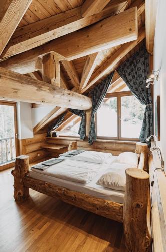 a large bed in a room with wooden ceilings at Mei Zeit Hüttendorf in Turracher Hohe