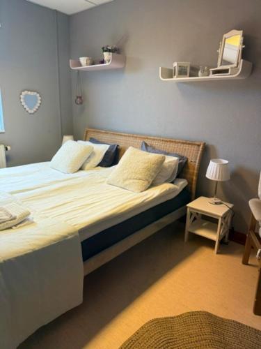 a bedroom with a bed and a table with a lamp at Mellerum på Österlen in Simrishamn