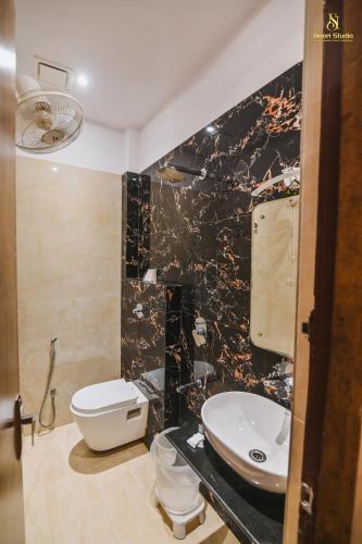 a bathroom with a white toilet and a sink at Bedi's Dream Land Hotel & Resort in Ayodhya