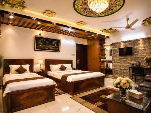 a bedroom with two beds and a living room at Star International Rajshahi - Near Aam chattar in Rājshāhi