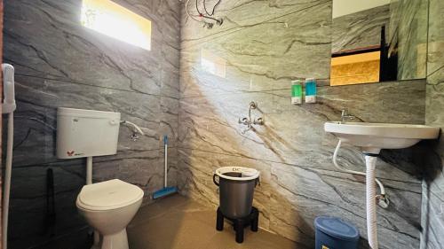 a bathroom with a toilet and a sink at Elite Boutique Stays in Ujjain