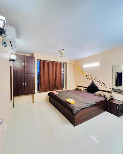 a bedroom with a large bed and a television at Paradise Villa in Lonavala