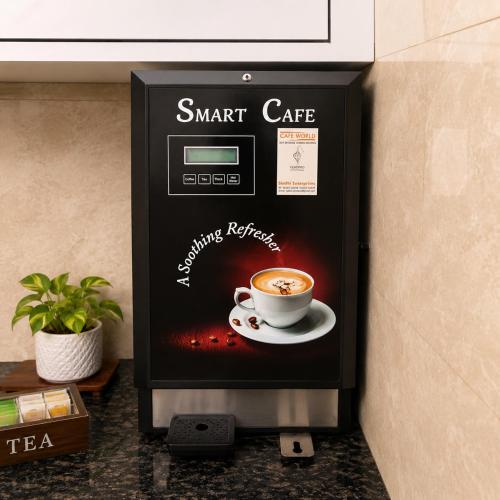 a small coffee machine with a cup of coffee at The Crown Resort in Sonīpat