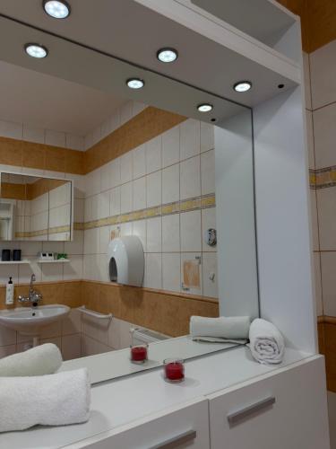 a bathroom with a large mirror and a sink at Hotel a Restaurant Výpřež in Děčín