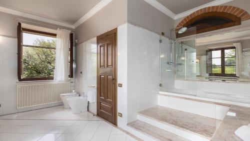 a bathroom with a sink toilet and a mirror at VILLA LA MONARCA 16, Emma Villas in Torrita di Siena