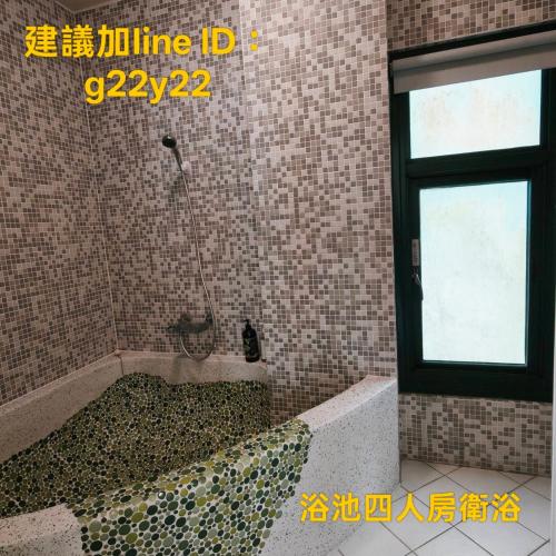 a bathroom with a bath tub with a window at Summer Homestay in Kenting