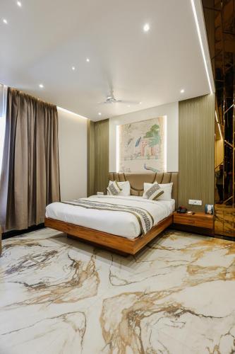 a bedroom with a large bed and a marble floor at Bedi's Dream Land Hotel & Resort in Ayodhya