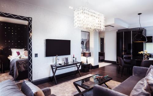 a living room with a couch and a tv at Arctic Light Hotel in Rovaniemi