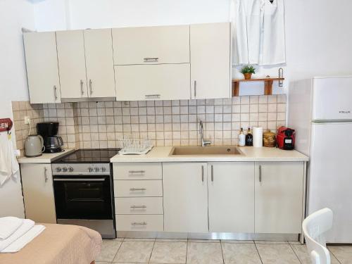 a kitchen with white cabinets and a sink at Polymnia's apartment in Matala