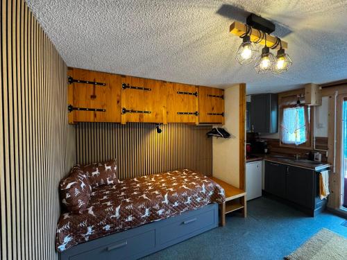 a bedroom with a bed and a kitchen with wooden cabinets at Ski1600 - GrandMassif in Samoëns