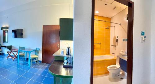 a bathroom with a sink and a toilet and a tub at Microtel by Wyndham Puerto Princesa in Puerto Princesa City