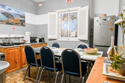 a kitchen with a table and chairs and a refrigerator at Sefranda Guesthouse in San Ġwann