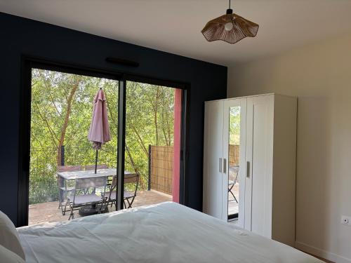 a bedroom with a bed and a table and a patio at Claïla Appart-Hôtel Abzac in Abzac