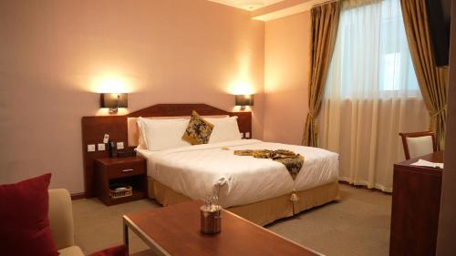 a hotel room with a bed and a table at Amdina Hotel in Mekʼelē