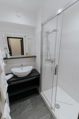 a bathroom with a sink and a glass shower at Almhof Lässer in Balderschwang