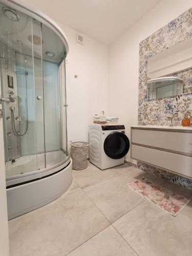 a bathroom with a shower and a tub and a sink at Rose in Portorož