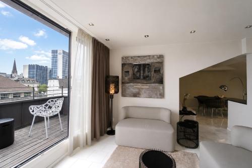 a living room with a balcony with a couch and a chair at VISIONAPARTMENTS Freyastrasse - self check-in in Zurich