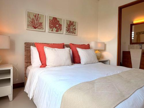 a bedroom with a large bed with red and white pillows at Beachfront Penthouse - Panoramic Ocean View in Cap Malheureux