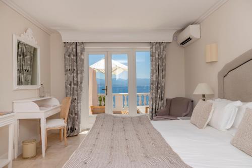 a bedroom with a bed and a desk and a window at Hôtel Les Mouettes - Teritoria in Ajaccio