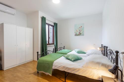 a bedroom with a large bed with green pillows at Apartment Šterna in Svetvincenat in Svetvinčenat