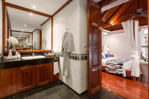 a bathroom with a bed and a sink and a mirror at Katamanda B2 Tropical Pool Villa Kata Beach in Kata Beach