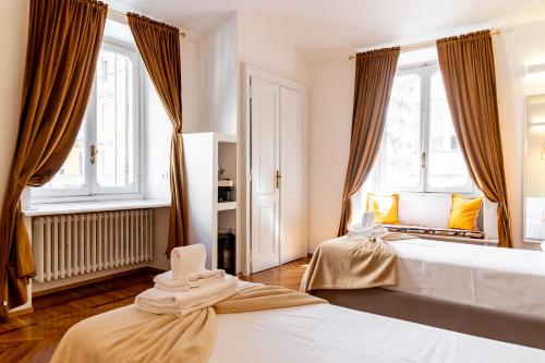 a bedroom with two beds and two windows at Turin Central Suite in Turin