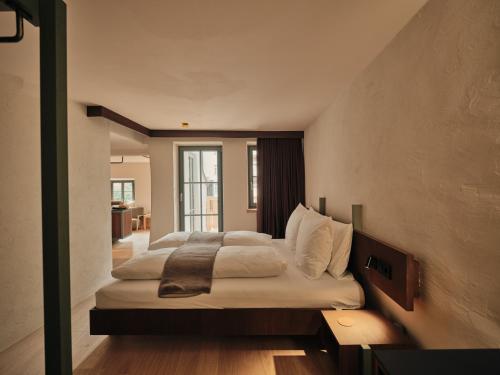 a bedroom with a large bed with white sheets at Stuveles Apartments in Brixen