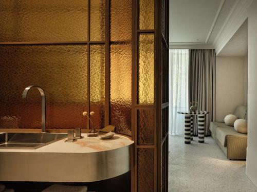 a kitchen with a sink and a living room at The Newel Kolonaki in Athens