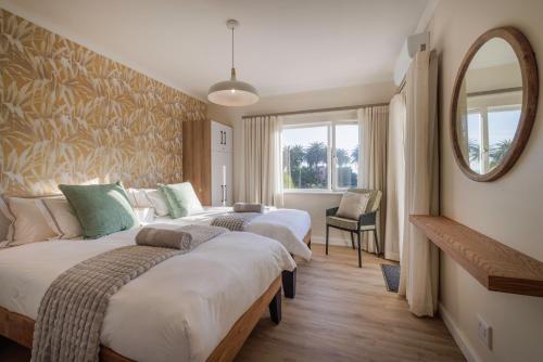 a hotel room with two beds and a mirror at Elegant Seaview Suite 1 in Swakopmund