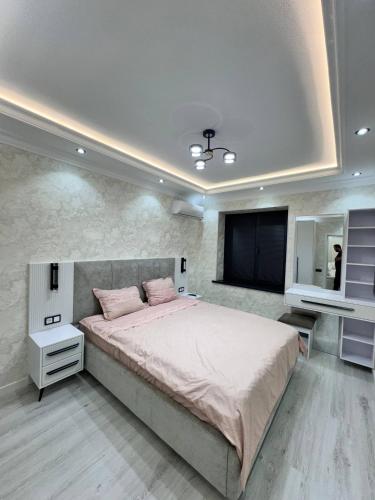 a bedroom with a large bed and a flat screen tv at Apartment Samarkand in Samarkand