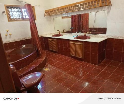 a bathroom with two sinks and a bath tub at Hotel Royal Inn in Karachi