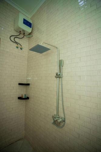a shower in a bathroom with a shower head at Pristine Stays in Moshi